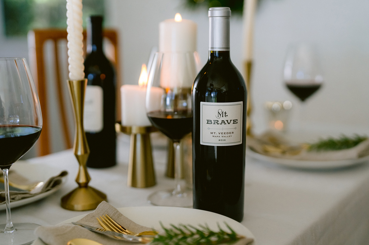 Bottle of Mt. Brave Wine on a dinning table with gold accents