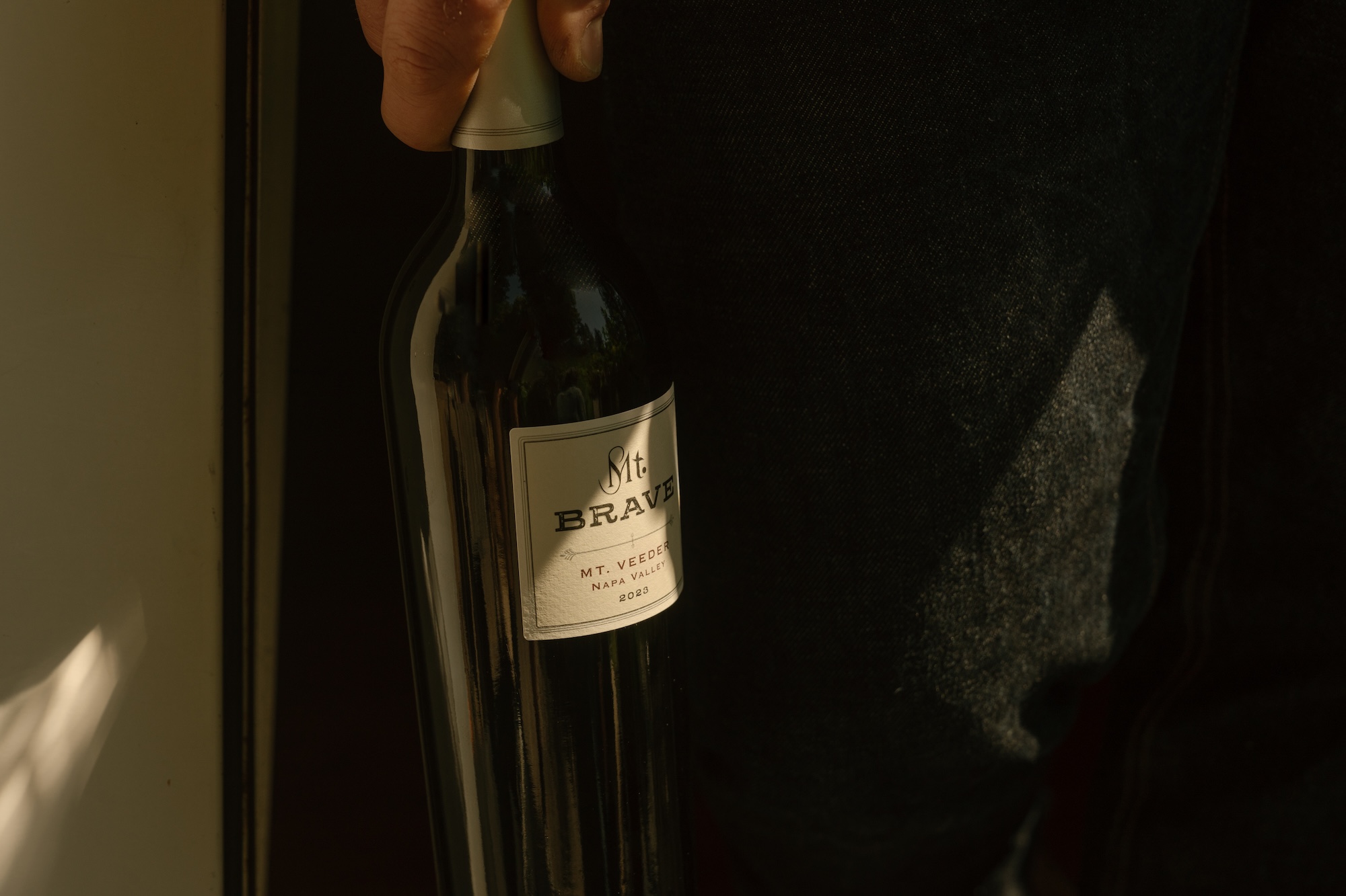 close up image of a person holding a Mt Brave Cabernet Sauvignon bottle