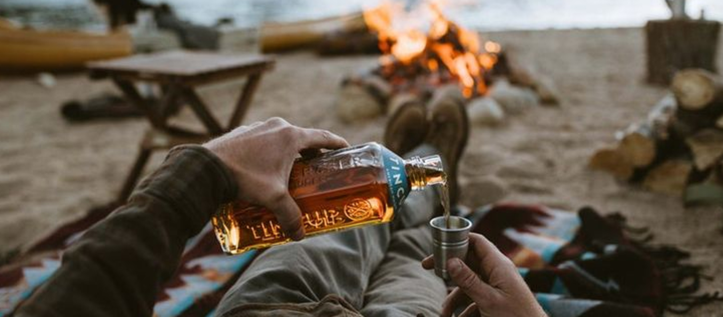 Close up of person pouring whiskey in a shot glass